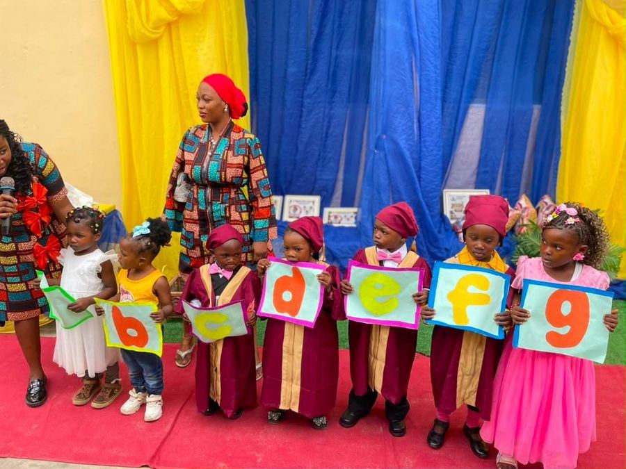 Nursery graduands holding up alphabet cards on stage
