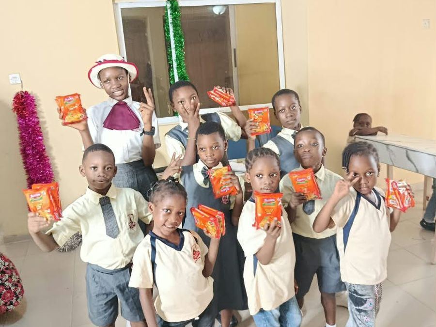 Pupils in uniform holding up their party treats