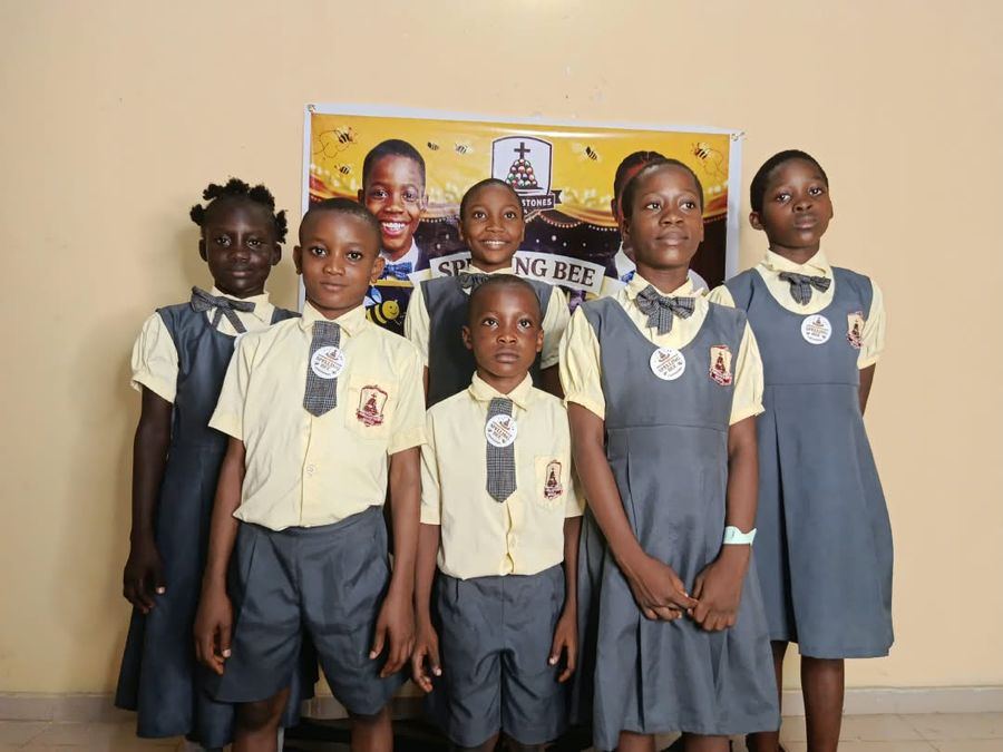 Spelling Bee finalists in uniform in front of the Spelling Bee banner